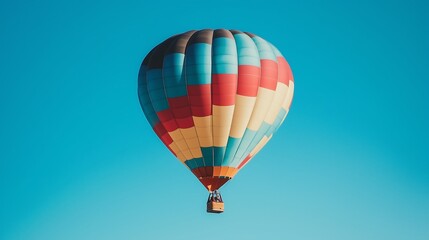 Obraz premium Colorful hot air balloon floating against a clear blue sky.