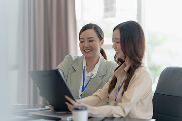 Asian office employee supervising Mentor training intern at office