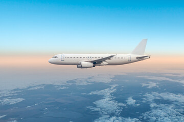 Fototapeta premium White passenger airliner fly in the air above the clouds