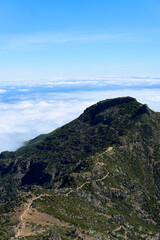 Stunning aerial view of a mountain peak above clouds on a clear day showcasing natural beauty and serene landscape