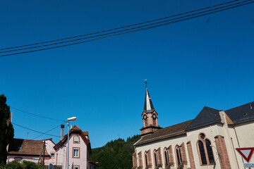 Obraz premium Beautiful clear sky over a traditional village with a church steeple and quaint houses in a rural area