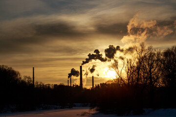 Heavy smoking chimneys at sunset in winter