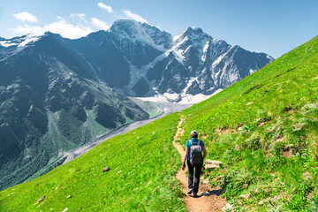 Obraz premium Picturesque view of the glacier seven with a tourist on the trail in sunny weather