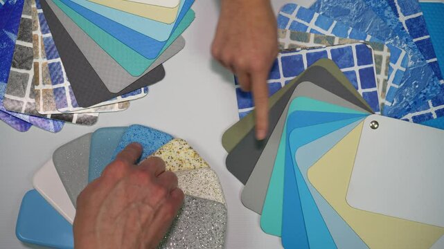 Choice of color and material for the pool. Two hands pointing on different swatches for swimming pool. Top view