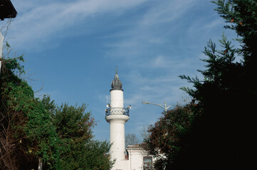 Stunning minaret against clear blue sky and green trees in &ccedil;engelk&ouml;y istanbul, turkey