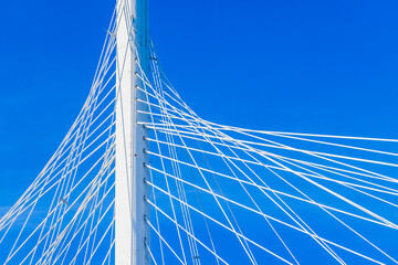White metal cable-stayed bridge details are under clear blue sky