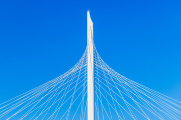 White metal cable-stayed bridge details are under blue sky