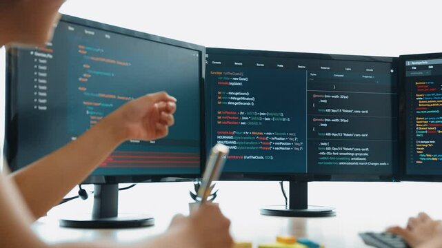 Slow motion back end software developer engineer for computer programming working together on debugging writing computing code, solving complex algorithms display on monitor in office. Burgeoning