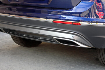 Fototapeta premium Blue Lux SUV exhaust pipe chromed made of stainless steel on powerful car bumper. Rear car exhaust pipe. Rear parking sensors on car bumper.