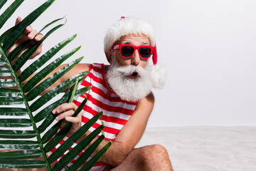 Photo of cheerful santa claus wear red striped swimsuit surprised seasonal sale open mouth isolated on white sandy beach background © deagreez