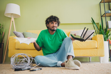 Full size photo of nice young man sit floor hold router shrug shoulder weekend green interior...
