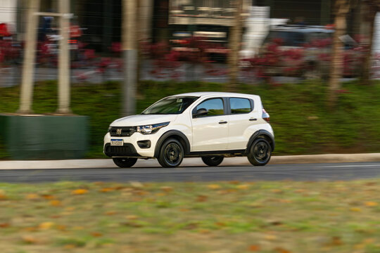 White Compact Car in movement, Fiat Mobi on urban street