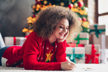 Photo of cute charming woman lying floor writing plans christmas preparation holidays magic...