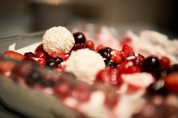 Delicious dessert featuring mixed berries and cream balls enjoyed at a festive gathering during the summer evening