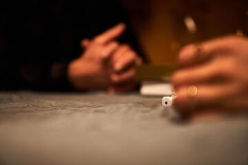 Focus on hands preparing for a conversation in a cozy indoor setting during a quiet evening