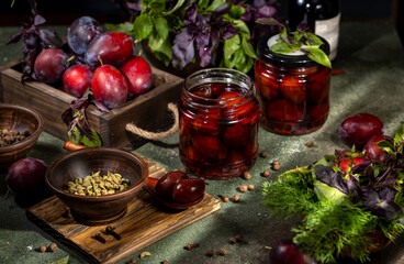 Pickled plums preserved in jars with aromatic herbs and spices