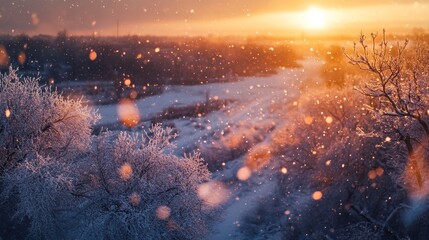 Winter countryside from above, with snow falling and the sun setting.