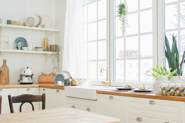 Empty white wooden kitchen interior with dining room. Scandinavian classic minimalistic bright kitchen with white and wooden details. Modern white kitchen clean contemporary style interior design