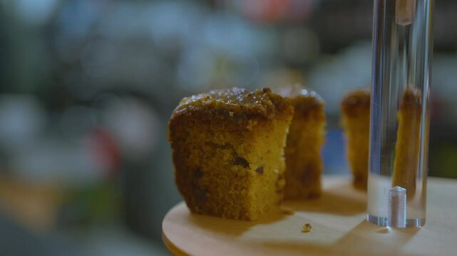 Professional baker putting slices of cake onto a display tower close up