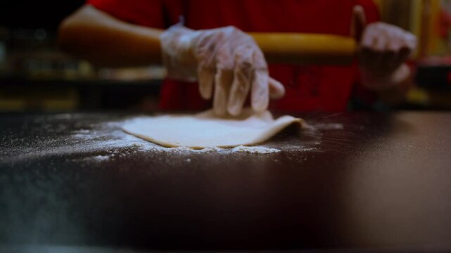 Rolling out dough slow motion in a professional kitchen