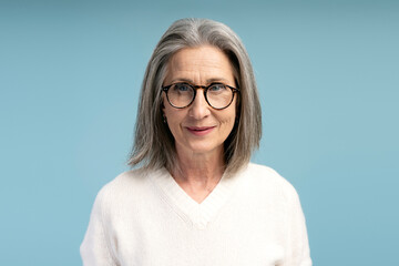 Fototapeta premium Portrait of smiling, beautiful senior woman wearing stylish eyeglasses, looking at camera