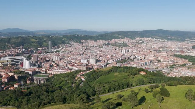 Aerial footage of the cityscape of Bilbao on a clear sunny day in the province of Biscay, Spain
