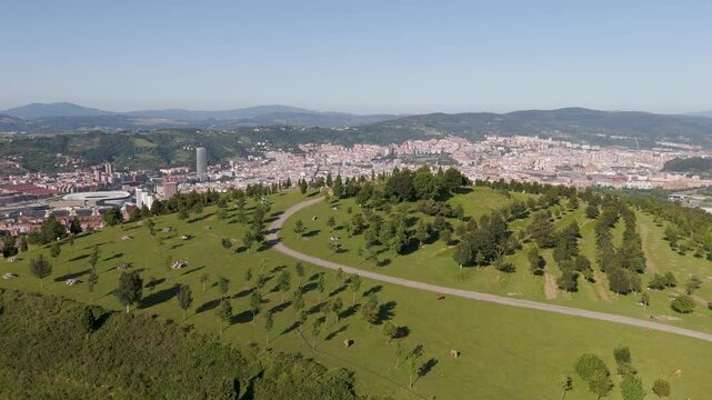Aerial footage of Mount Cobetas overlooking the city of Bilbao on a sunny day in Biscay, Spain
