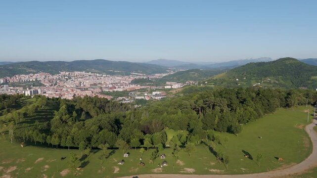 Drone footage of the green Mount Cobetas in the city of Bilbao on a clear sunny day in Biscay, Spain
