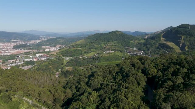Aerial footage of the green mountains surrounding Bilbao city on a sunny day in Biscay, Spain