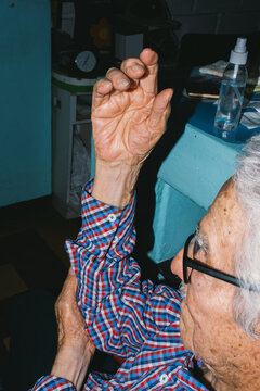 Elderly man&rsquo;s wrinkled hands adjusting shirt 