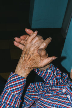 Elderly man rubbing his wrinkled hands 