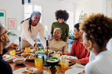 Happy family is sitting at the table and having dinner together