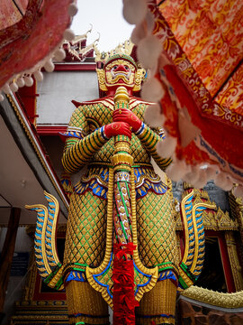 A large Buddhist statue behind fabric umbrellas at a temple in Bangkok