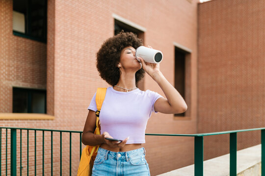 Woman drinking from a reusable bottle.