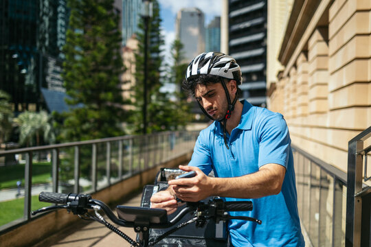 Delivery man taking his mobile phone upon arriving at the address