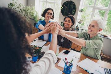 Portrait of team ambitious business women pile stack handshake desk modern interior office indoors