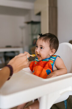 Baby with Open Mouth Eager for Spoonful in Chair
