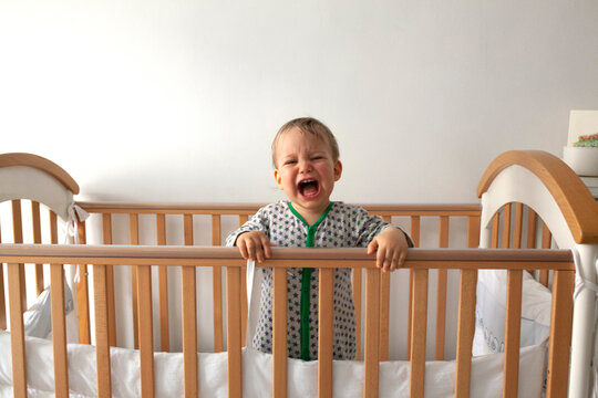 Portrait of a crying child in the cradle