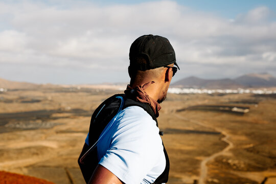 Man in hiking clothes appreciates the view from top of a viewpoint