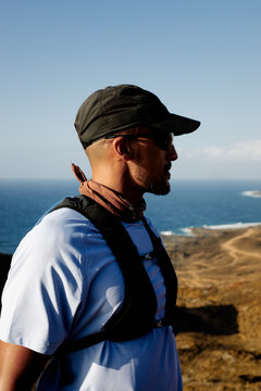 Man dressed in sportswear enjoys the scenery from the top of a volcano