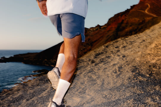 Unknown trail runner climbing a steep path of a volcano in Lanzarote