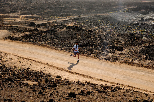 Man enjoys an adventure running on the dirt roads near the volcanoes