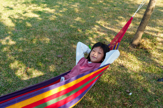 Naklejki Asian kid hanging out in hammock