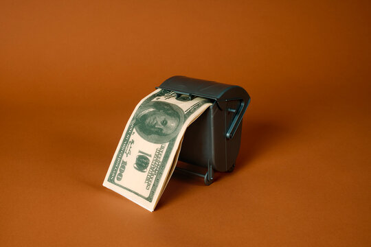 fake dollars in a gray waste container