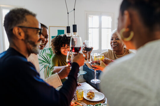 Happy family is toasting while having lunch together at home
