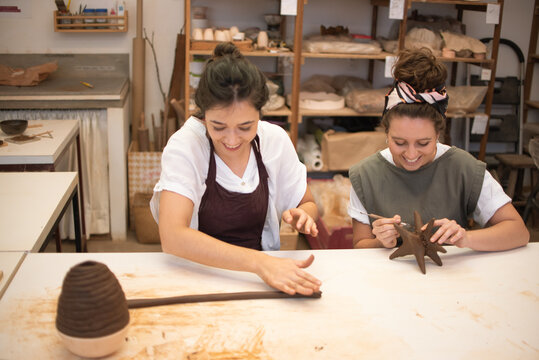 Two friends taking a sculpture class together