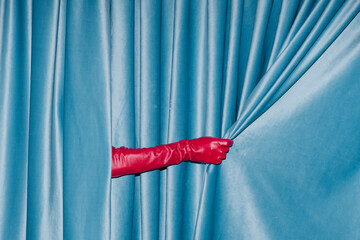 Red Gloved Hand Opening Blue Velvet Curtain