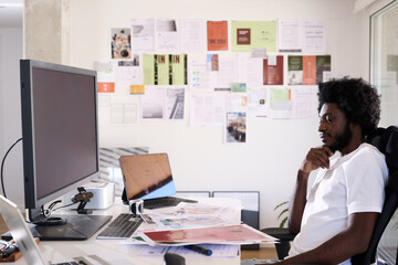 Creative designer sitting at the desk of his creative studio loo