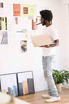 Creative designer standing in front of a moodboard of pending bu