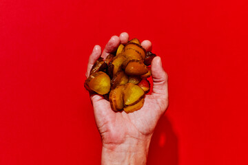 man has a handful of sliced pickled cucumbers